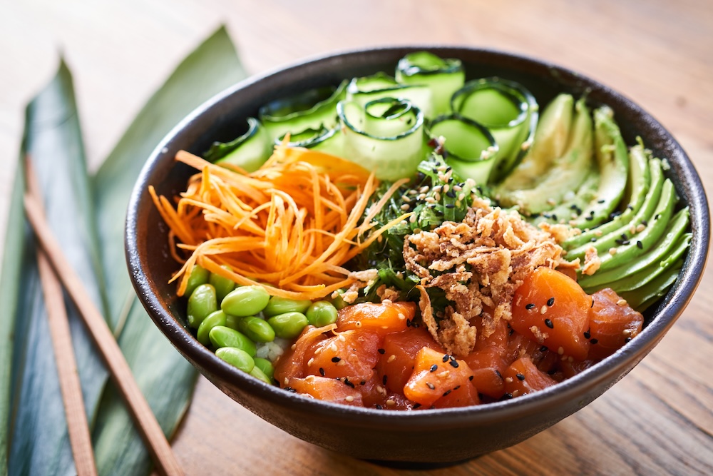 Poke bowl on wooden background.