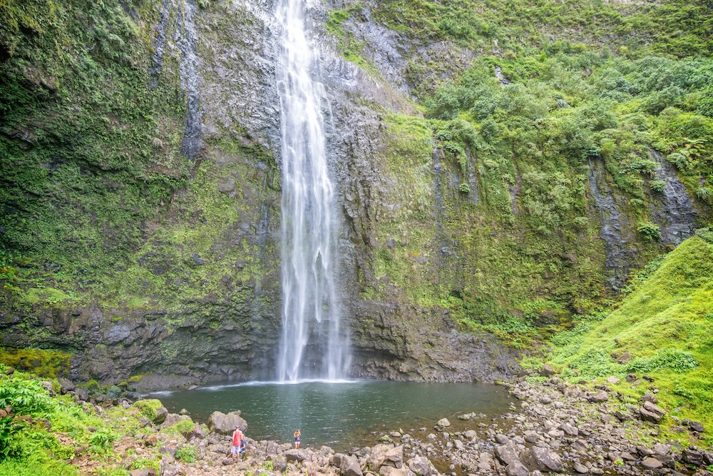 Tourists enjoying the amazing Hanakapi'ai falls in Kauai island, Hawaii