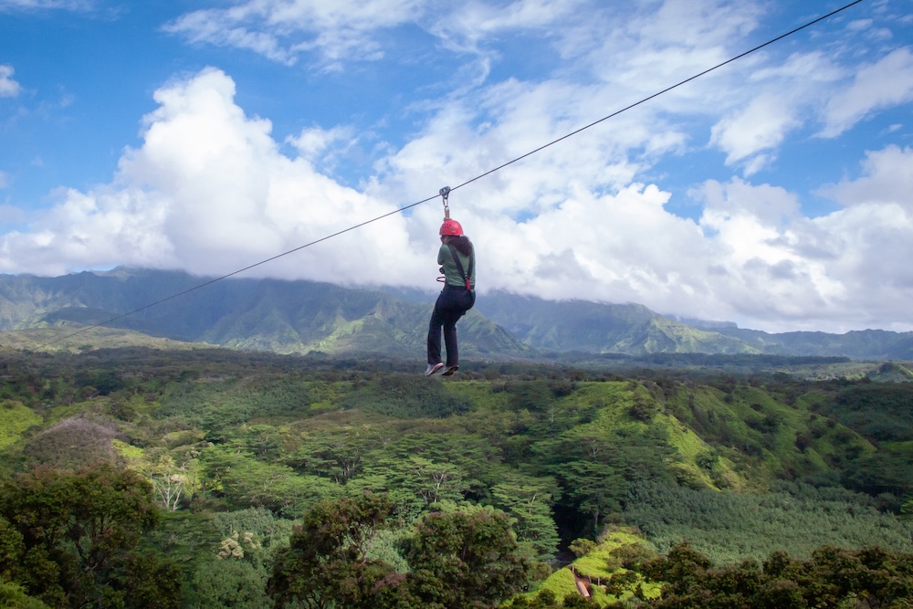 woman riding zipline in hawaii